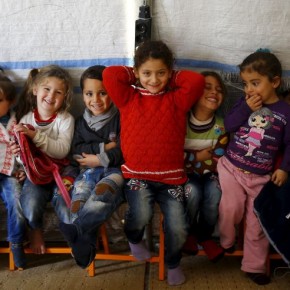 Syrian refugee girl Ele Cundi, 5, poses as she sits with her friends in a kindergarten at Midyat refugee camp in Mardin province, Turkey, December 14, 2015. Syria's conflict has left hundreds of thousands dead, pushed millions more into exile, and had a profound effect on children who lost their homes or got caught up in the bloodletting. The drawings of young refugees living in Turkey show their memories of home and hopes for its future. The pictures also point to the mental scars borne by 2.3 million Syrian refugees living in Turkey, more than half of them children. REUTERS/Umit Bektas